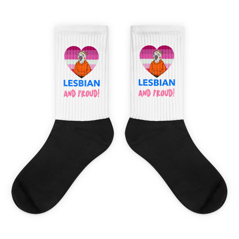 Pair of black-and-white crew socks reading “LESBIAN AND PROUD!” with heart graphics