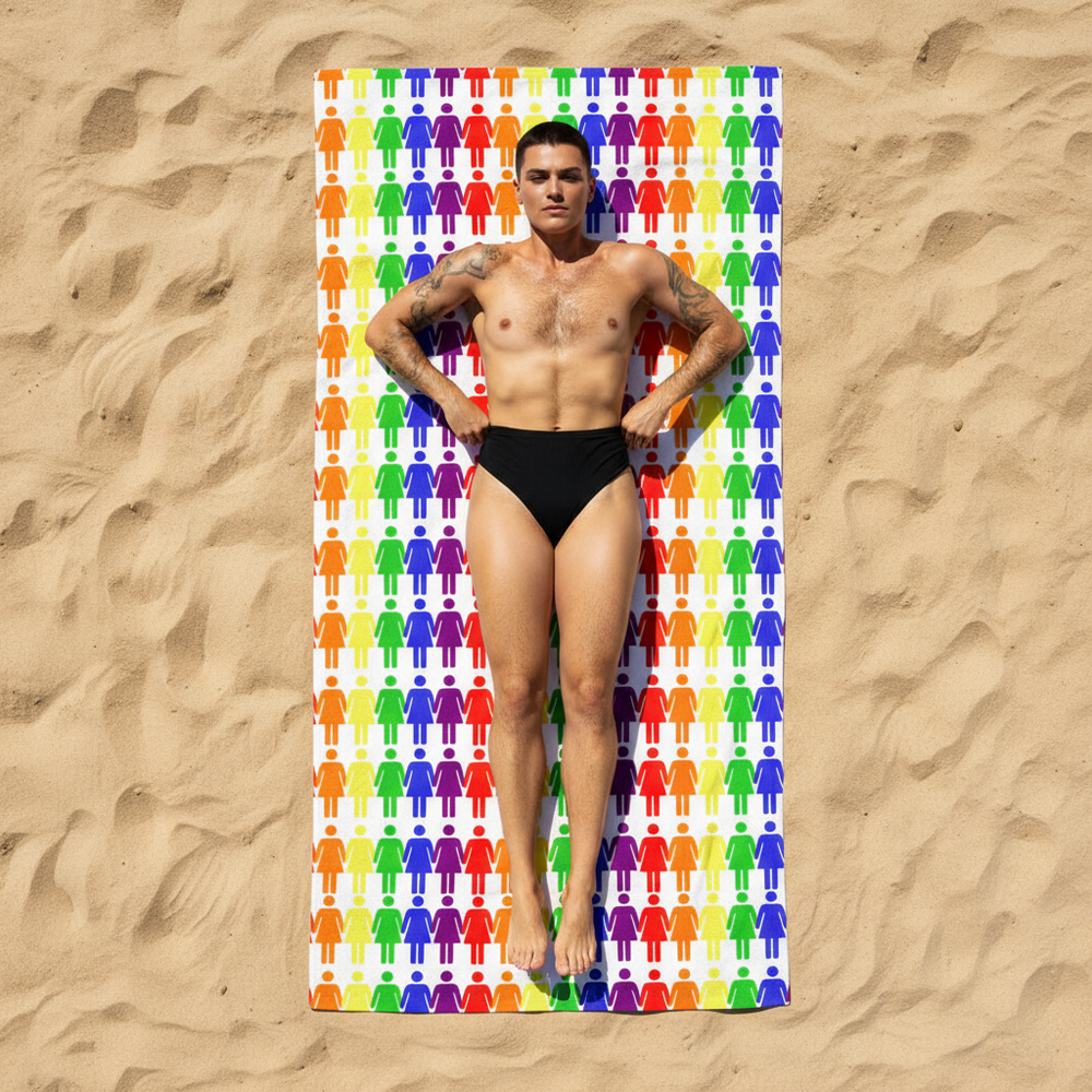 Lesbian Pride beach towel with rainbow human figure icons on sand, a tattooed person in black swim briefs lies flat