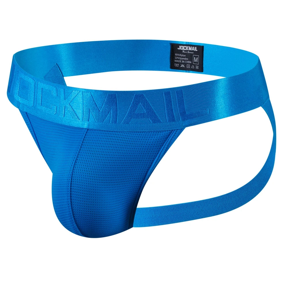 bears underwear: Shirtless, muscular person with a shaved head and beard models Let Them Eat Cake Jockmail Jockstrap in a dim