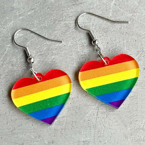 Pair of rainbow-striped acrylic heart dangle earrings on silver hooks