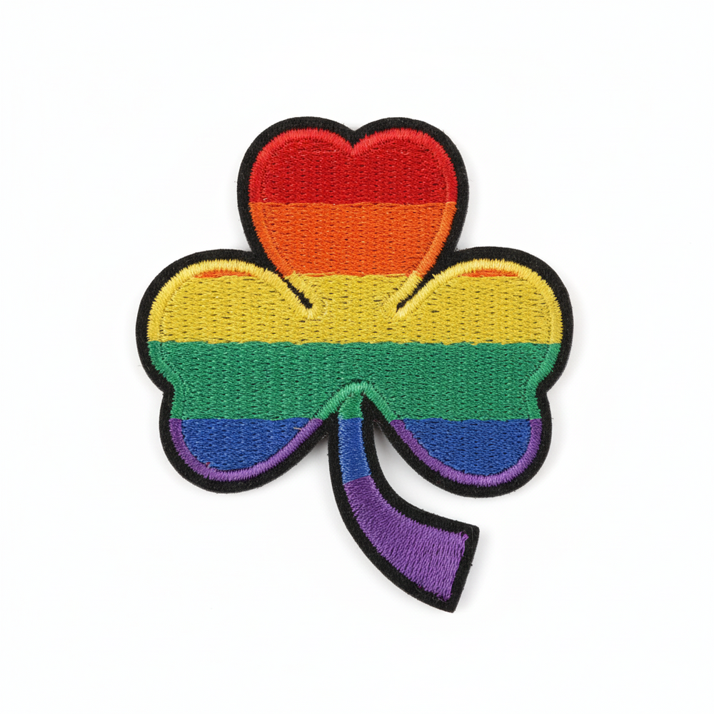 Embroidered iron-on patch shaped like a lucky clover in rainbow Pride colors