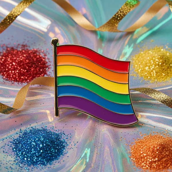 Rainbow LGBT Pride flag enamel pin on an iridescent surface with scattered glitter