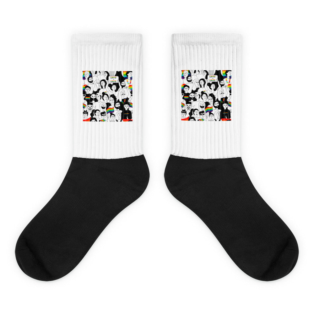 Pair of black-and-white crew socks with colorful illustrated faces and rainbow motifs