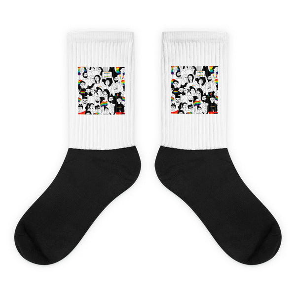 Pair of black-and-white crew socks with colorful illustrated faces and rainbow motifs