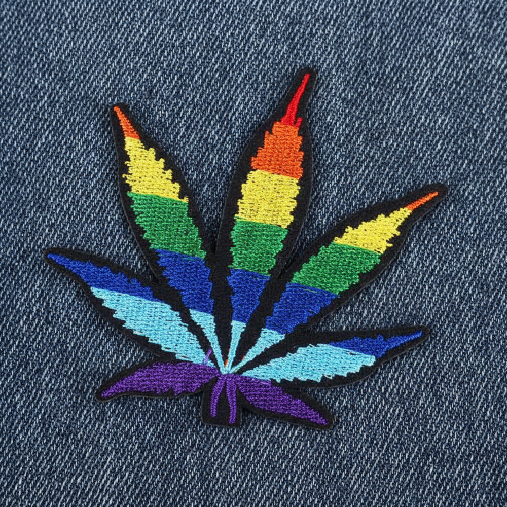 Embroidered LGBT Pride cannabis leaf iron-on patch on dark denim