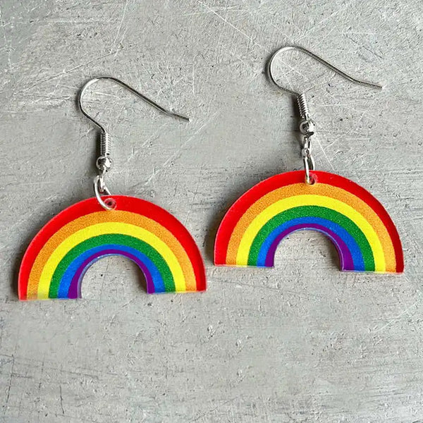 Pair of rainbow-arc acrylic dangle earrings with silver hooks, shown on a gray surface
