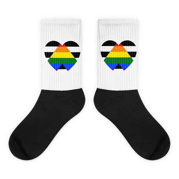 Pair of black-and-white crew socks with rainbow-striped geometric heart designs