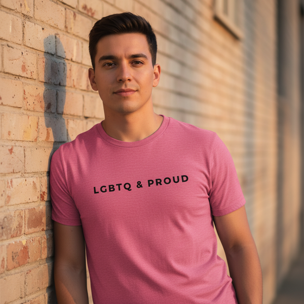 LGBTQ & Proud Unisex T-shirt with “LGBTQ & PROUD” in bold black letters worn by a person smiling by a sunlit brick wall