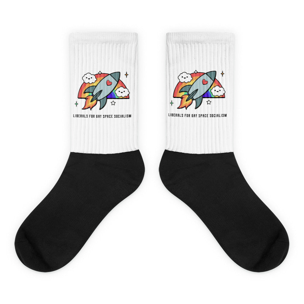 Pair of black-and-white socks with a rainbow rocket graphic and printed slogan