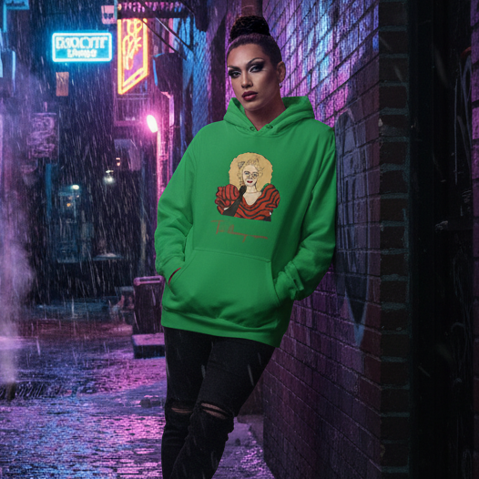 Model wearing a green hoodie with a cartoon portrait and faint red lettering in a rainy alley