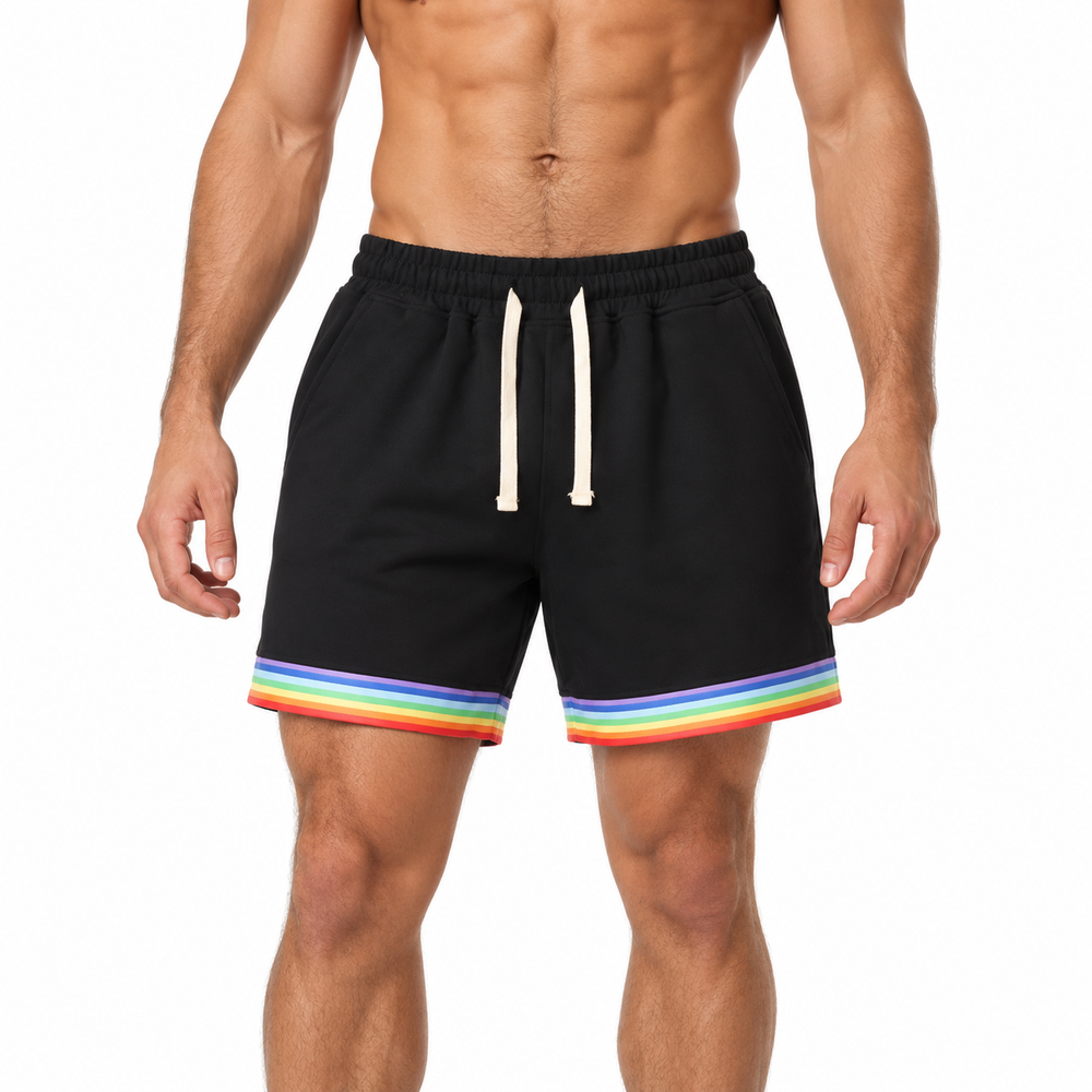 Front close-up of black Love is Love basketball shorts with rainbow hems and drawstring waist on a shirtless man against white.