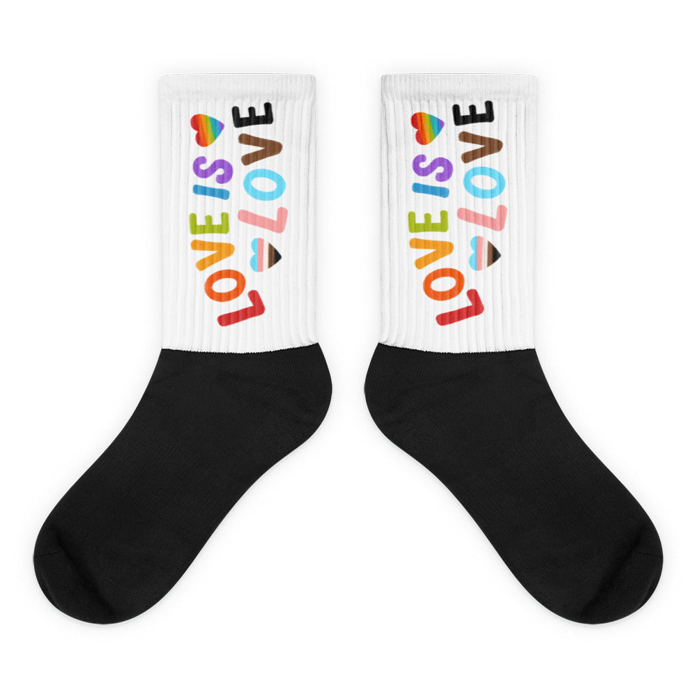 Pair of black-and-white socks with colorful LOVE IS LOVE lettering and heart motifs