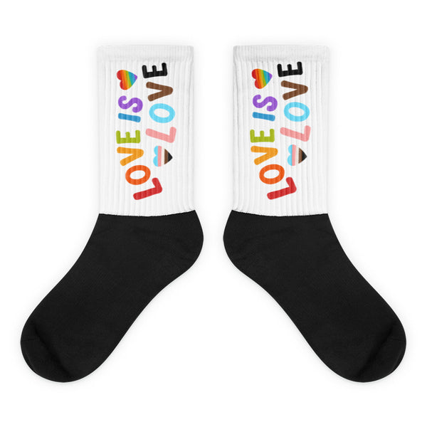 Pair of black-and-white socks with colorful LOVE IS LOVE lettering and heart motifs