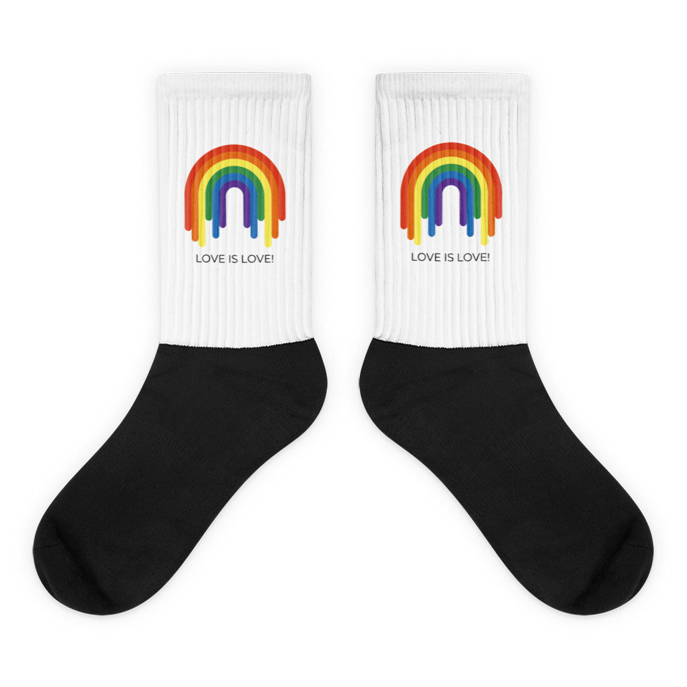 Pair of black-and-white crew socks with rainbow graphics and “LOVE IS LOVE!” text
