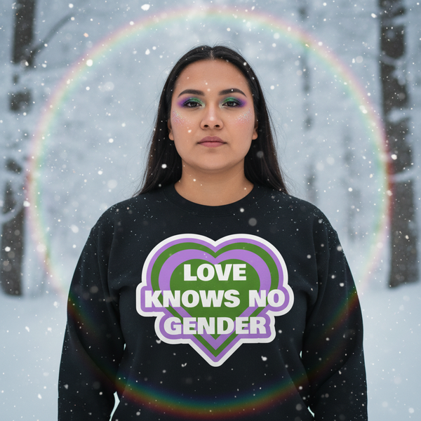Person in falling snow wearing a black sweatshirt reading “LOVE KNOWS NO GENDER”