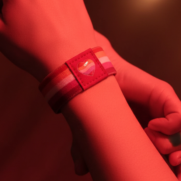 Close-up of a red-striped wristband with a heart patch on a person's wrist