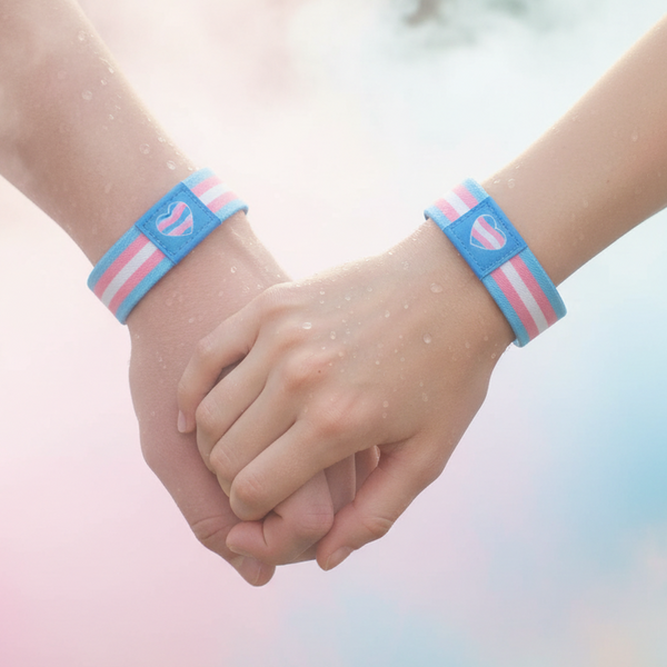 Two people hold hands, wearing matching blue, pink, and white striped heart bracelets