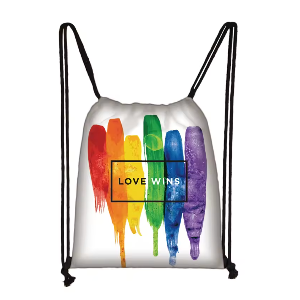 Close-up of a white drawstring bag with rainbow paint stripes and “LOVE WINS” text