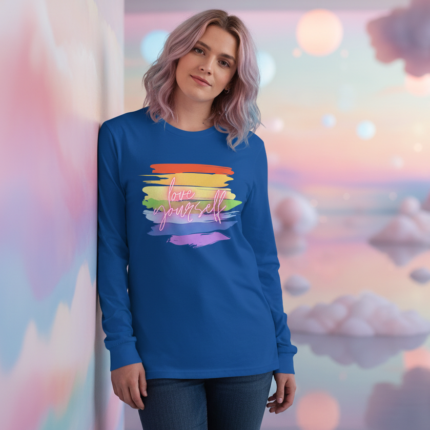 Unisex long sleeve tee with rainbow brushstroke and “love yourself” slogan, worn by woman with pastel purple hair. Soft vibe.