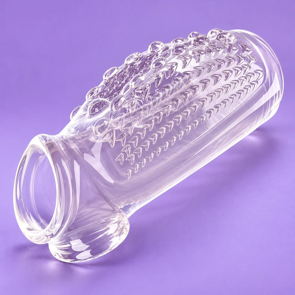 Transparent Magnify Master penis extension sleeve showing its hollow opening and textured surface against lavender.