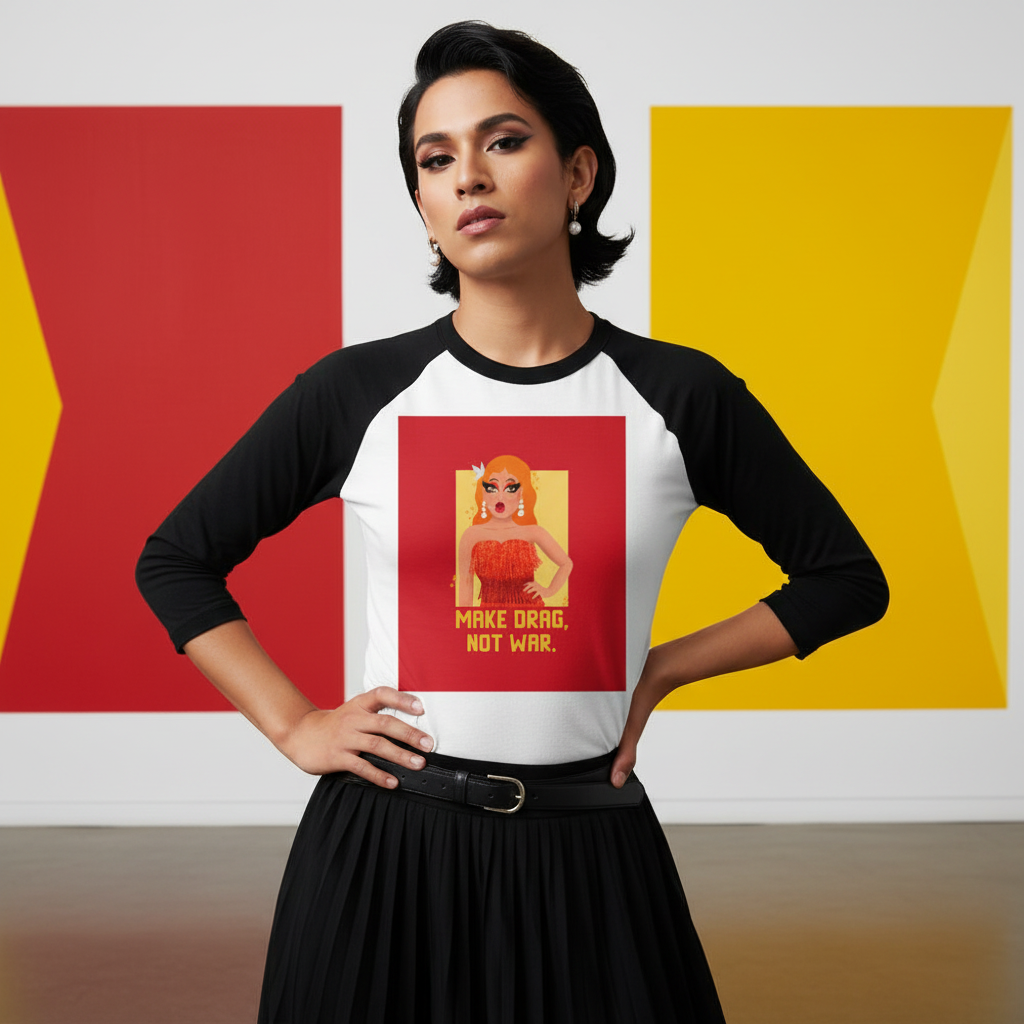 3/4 sleeve raglan shirt, “MAKE DRAG, NOT WAR” text, illustrated drag queen. White walls with bold geometric shapes behind.