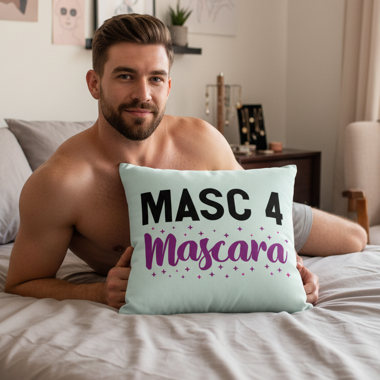 A shirtless person with short hair and a beard smiles on a bed