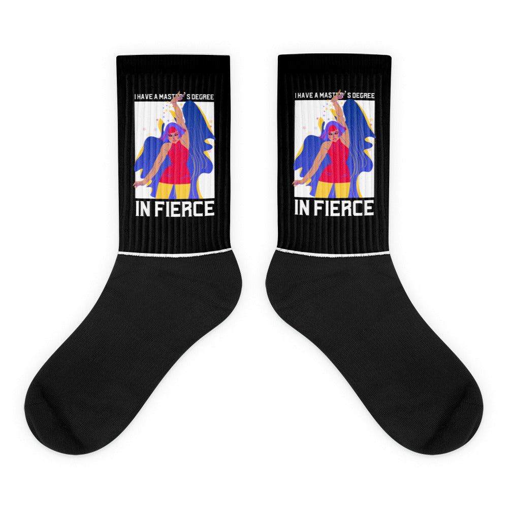 Pair of black crew socks with colorful illustrated women and the words “I HAVE A MASTER’S DEGREE IN FIERCE”