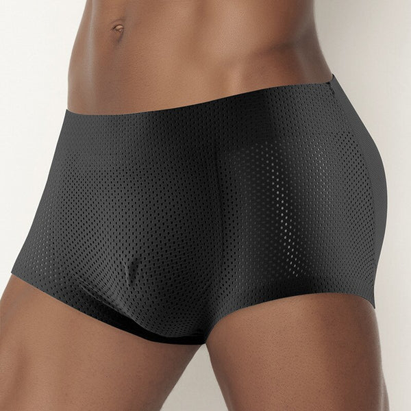 Close-up front view of a model wearing black perforated men's enhancing boxer briefs