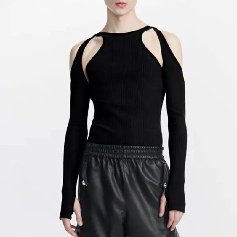 Front view of a model wearing a black long-sleeve top with shoulder cut-outs and black leather-look pants