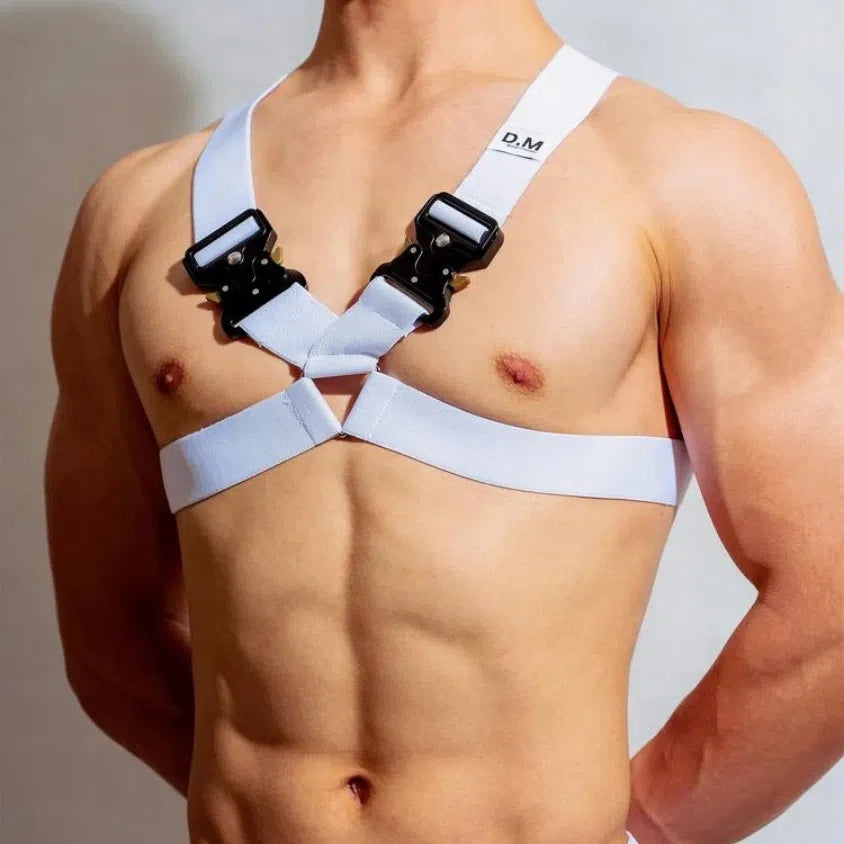 Front view of a shirtless model wearing a white chest harness with black metal buckles