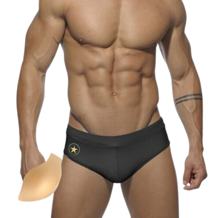 Front-view model wearing black swim briefs with a gold star emblem