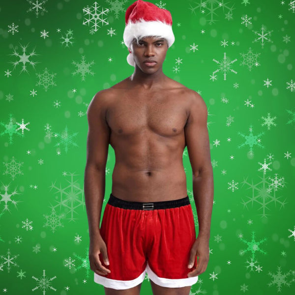 Front-facing shirtless person wearing a Santa hat and red velour shorts with white trim