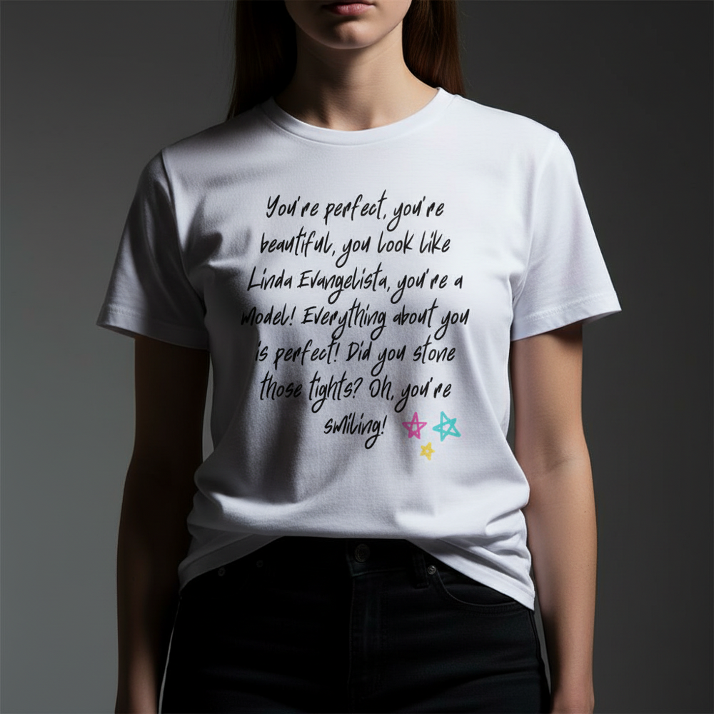 Unisex pride T-shirt with handwritten black text "You Look Like Linda Evangelista" and rainbow star doodles along the bottom.