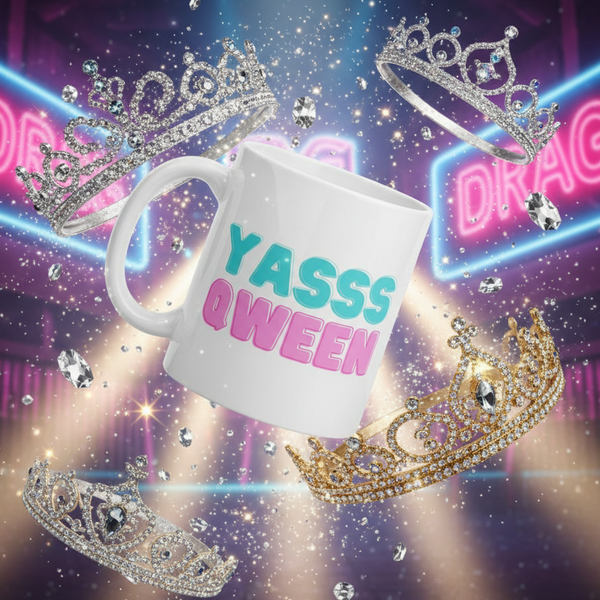 White mug with colorful “YASSS QWEEN” lettering surrounded by sparkling tiaras and jewels