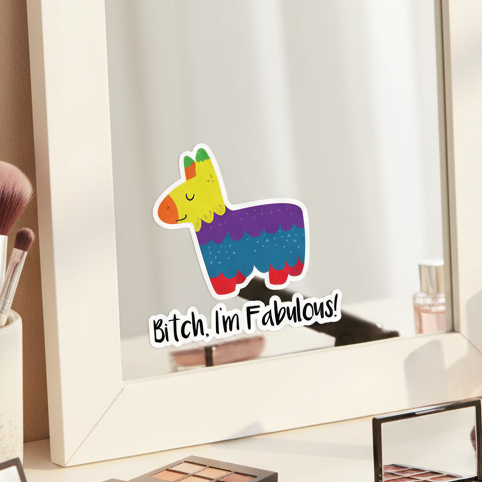 Bitch I'm Fabulous! Bubble-Free Sticker" with a queer-color cartoon llama, stuck on a vanity mirror by makeup and brushes.