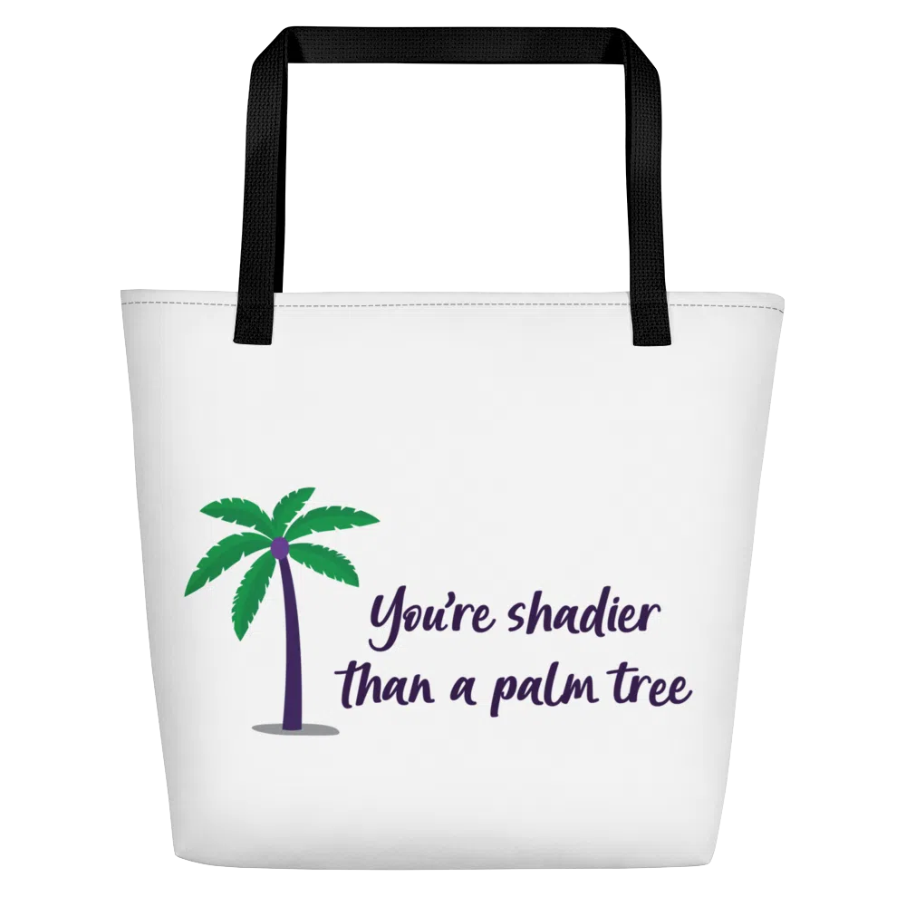 White tote bag with black handles, palm tree graphic, and “You’re shadier than a palm tree” text