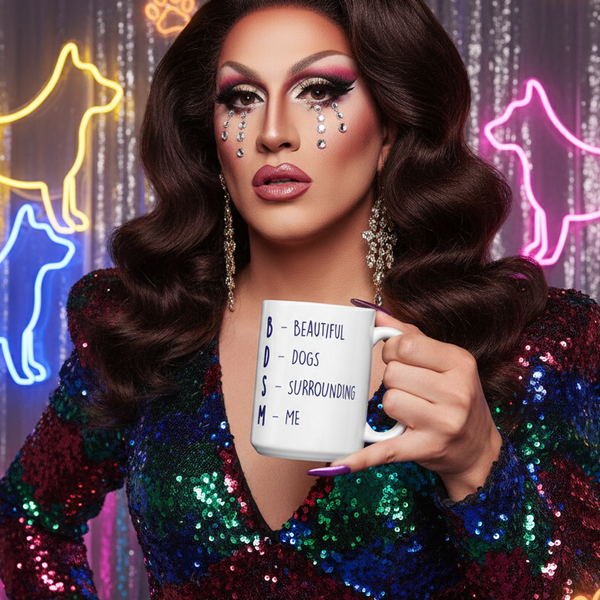 Drag performer holding a white mug printed “BDSM – Beautiful Dogs Surrounding Me”
