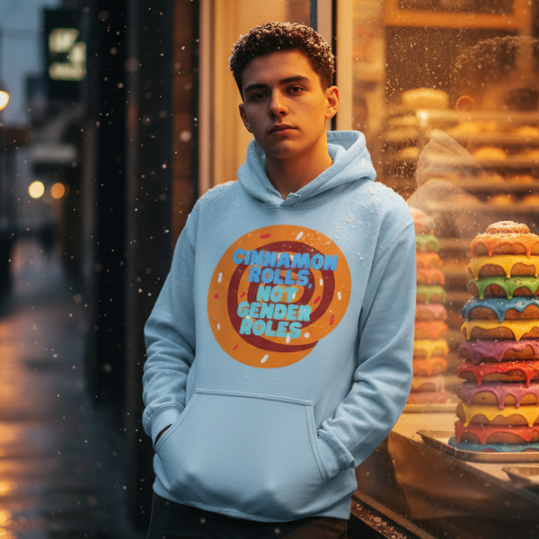 Model wearing a light blue hoodie reading “CINNAMON ROLLS, NOT GENDER ROLES” outside a bakery