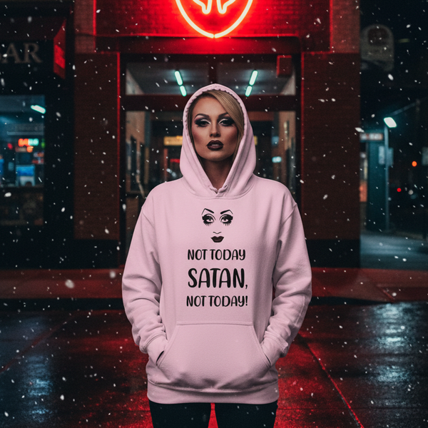 Drag performer wearing a pink hoodie reading “NOT TODAY SATAN, NOT TODAY!” in a snowy street