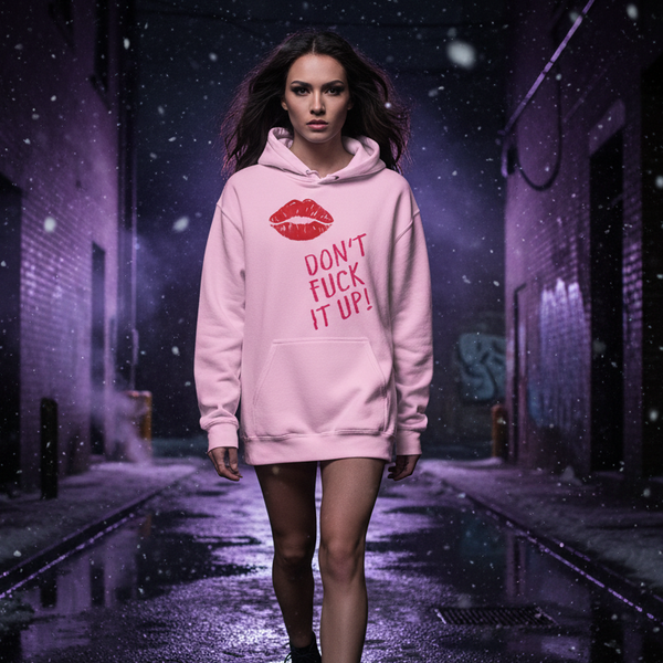 Pink hoodie with red lips graphic and “DON’T FUCK IT UP!” slogan, worn on a snowy street