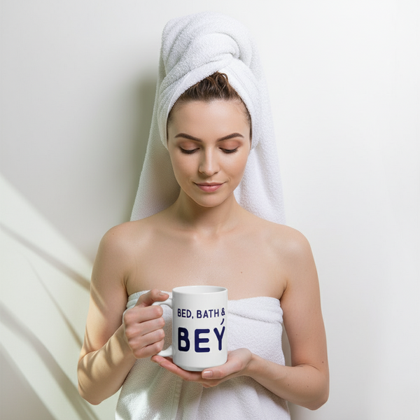 Close-up of a person holding a white “BED, BATH & BEY” mug while wrapped in a towel