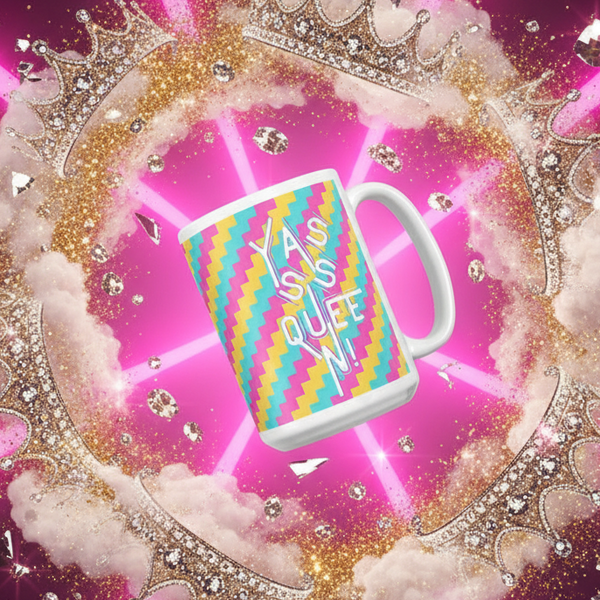 Close-up of a colorful mug reading “YASSS QUEEN” against a pink, glittery crown backdrop