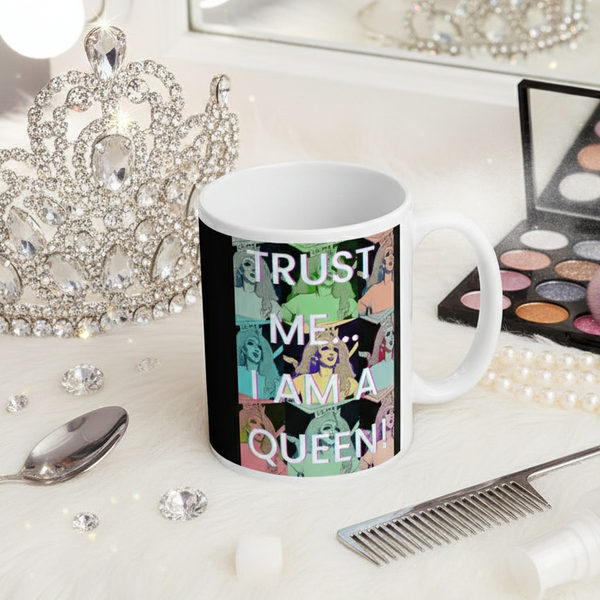 Trust Me I'm A Queen Mug amidst glam vanity scene with rhinestone tiara, pearl necklace, and shimmery makeup palette, capturing bold queer empowerment and joyful self-expression from Queer In The World.