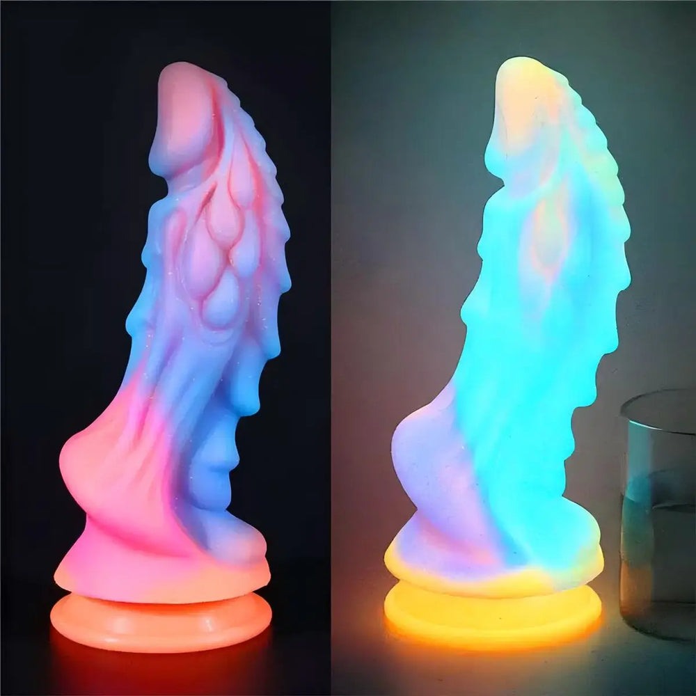 Two views of a glowing, ridged fantasy dildo with a wide suction base