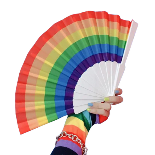 Open rainbow folding hand fan held in a painted, bracelet-wearing hand