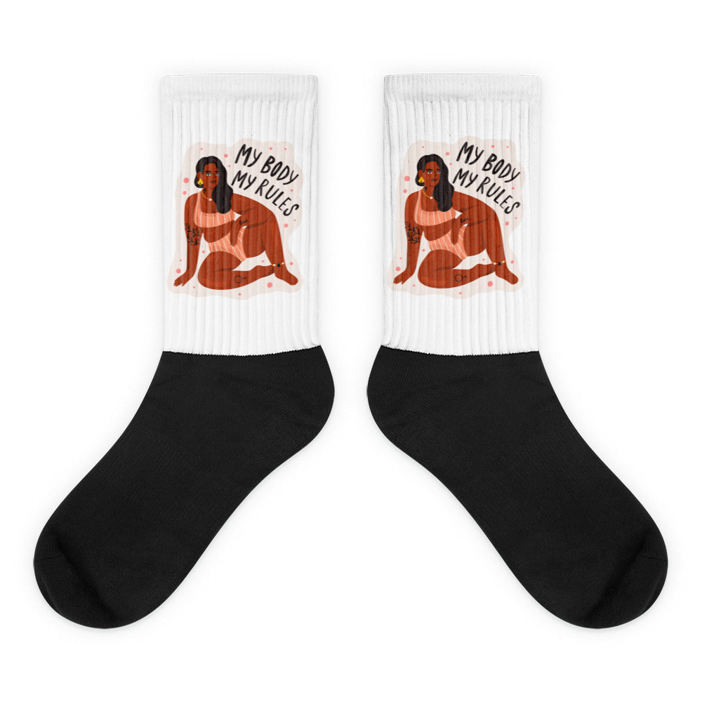 Pair of black-and-white crew socks with a seated figure and “MY BODY MY RULES” text