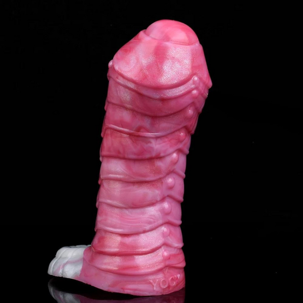 Pink ribbed penis extension standing upright against a black background