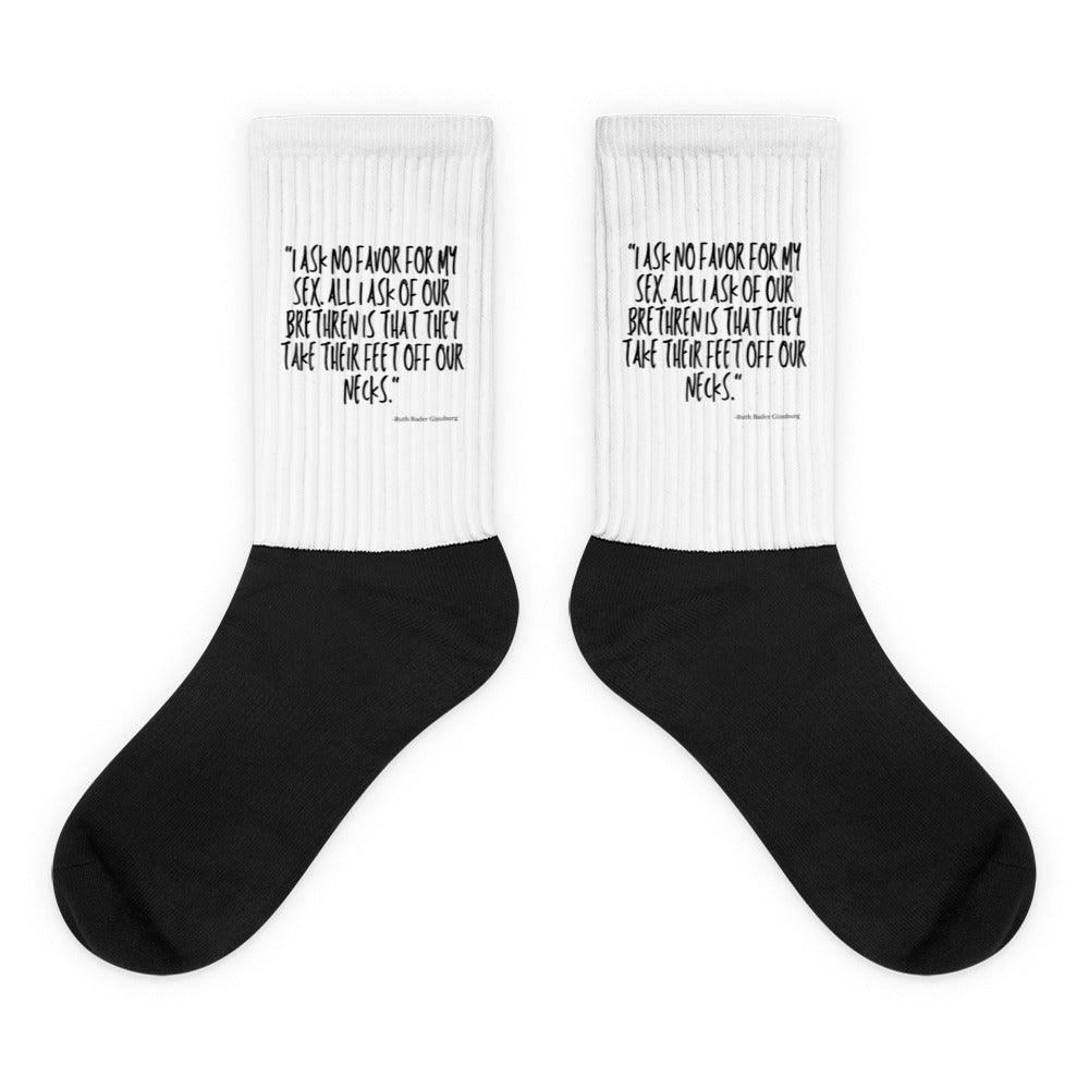 Pair of black crew socks with white cuffs reading “I ask no favor for my sex”
