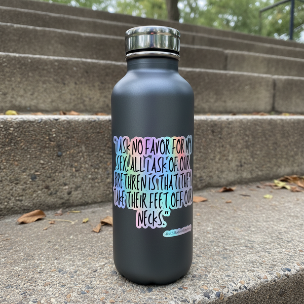 Holographic quote sticker on a matte black bottle on outdoor concrete steps