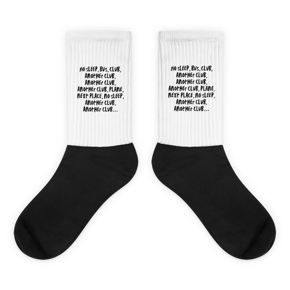 Pair of black-and-white ribbed socks with repeated club-themed text on the white cuffs